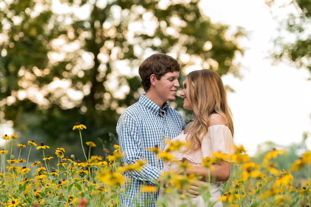 couple standing in wildflowers at sunset